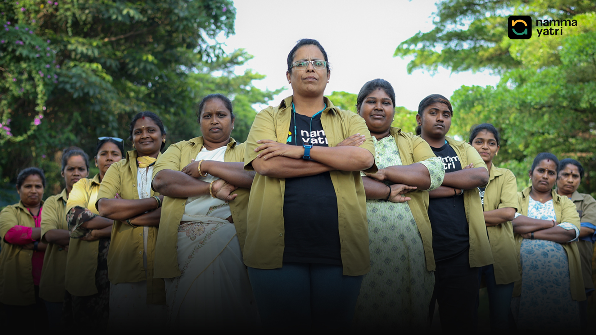 A group of Mahila Shakti women drivers standing arm-in-arm in their uniform jackets