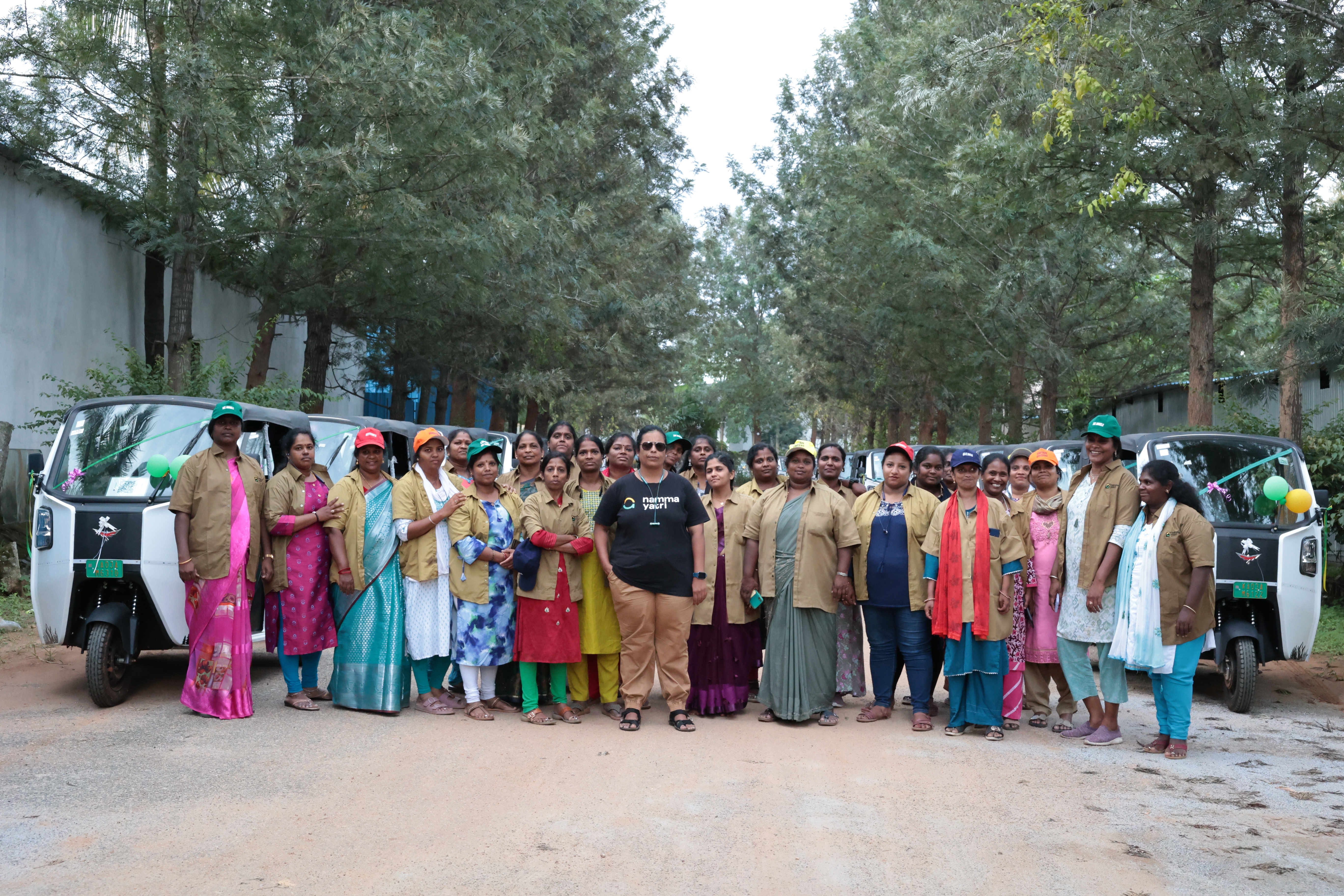 A large cohort of Mahila Shakti women drivers gathered together in front of their autos