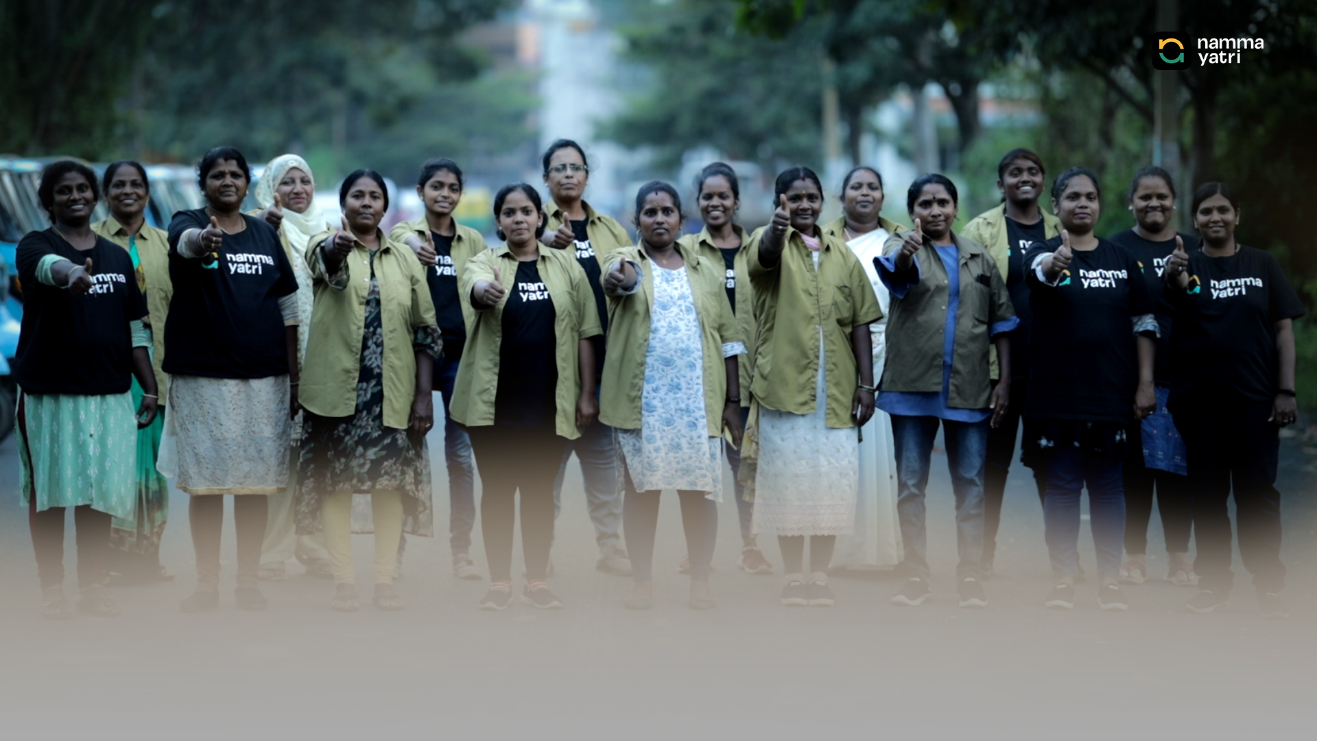 A row of Mahila Shakti drivers giving a thumbs up on a Bengaluru street