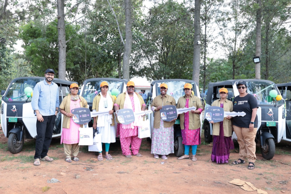 Women drivers holding their EV auto keys at a handover ceremony
